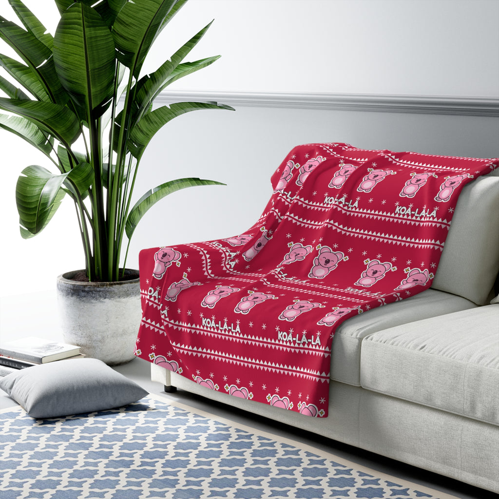 Koa-la-la Christmas sherpa blanket in a cosy room setting